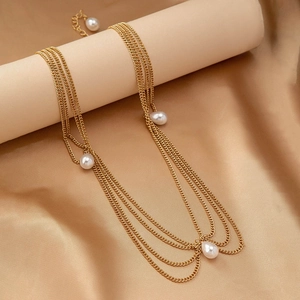 Bohemian gold layered chain headpiece with white pearl tassels on satin background