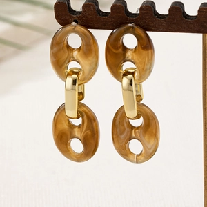 Detailansicht der Vintage-Ohrringe aus bernsteinfarbenem Harz mit goldenen Metallringen