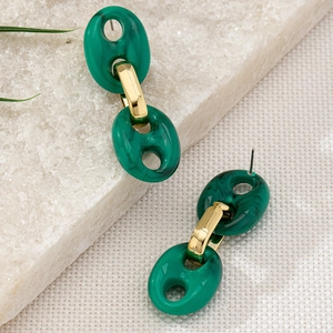 Detail von Vintage-Ohrringen aus grünem Marmor-Resin und Goldkette auf Texturhintergrund
