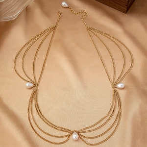 Detail of layered gold chain headpiece with white pearl drops on champagne silk