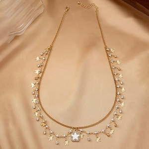 Détail du collier doré double épaisseur avec breloques papillons et pendentif trèfle