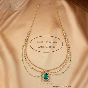 Détail du collier bohème doré avec pendentif goutte verte et accents de cristal brillant
