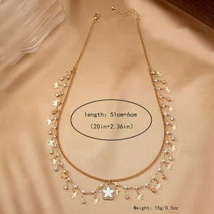 Détail du collier doré multicouche avec trèfle papillon et cristaux, longueur 51+6cm