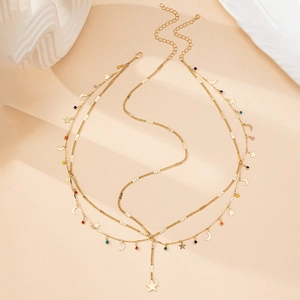 Détail macro du bijou de tête bohème multicouche avec breloques étoile lune et perles colorées