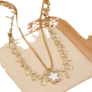 Collier doré double couche avec charms papillon et pendentif fleur de trèfle