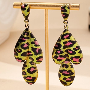 Pop art teardrop earrings featuring neon yellow leopard print on a gold display stand