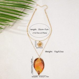 Detail view of double-layer necklace with golden flower and leaf pendant size specifications