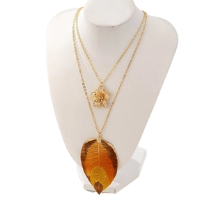 Elegant gold double-layered necklace featuring a floral pendant and enameled leaf charm