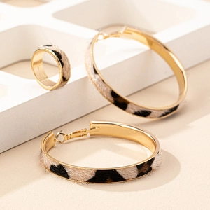 Conjunto de joyas geométricas doradas con pendientes y anillo de estampado leopardo