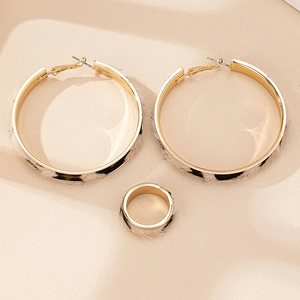 Primer plano de pendientes de aro y anillo dorados con textura de estampado de leopardo