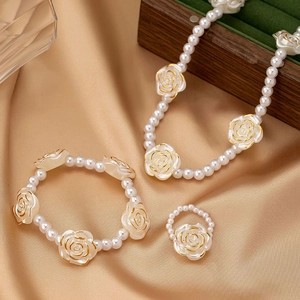 Elegantes Schmuckset mit Perlenkette, Armband und Ring mit goldenen Rosendetails