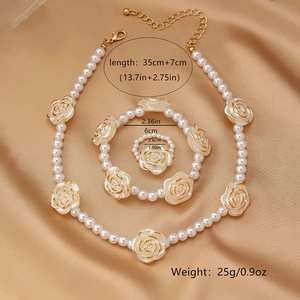 Detailansicht von rotem Rosen-Perlen-Schmuckset mit Kette Armband und Ring auf Seide