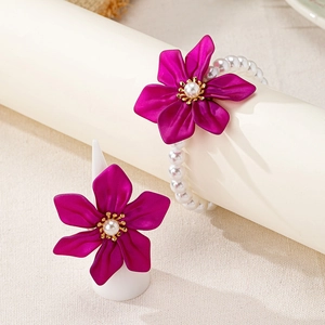 Detail of rose flower ring and pearl bracelet jewelry set on beige display stands