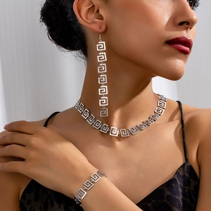 Three-piece geometric spiral jewelry set with necklace earrings and bracelet on model