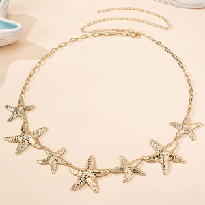 Detailed close-up of golden starfish waist chain with textured metallic finish and tassels