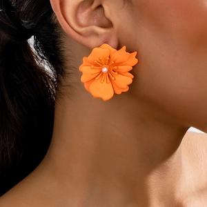 Detail von orangefarbenen Blumenohrringen mit strukturierten Blüten und Perle