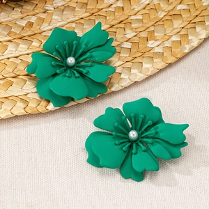 Detailaufnahme grüner matter Blumenohrringe mit Perlen auf Sommer-Dekoration