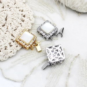 Detailed view of 18K gold plated square pearl clasps with pavé zircon and shell inlay