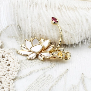 Elegant 18K gold lotus brooch with white mother-of-pearl and red gemstone accents