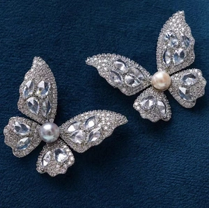 Funkelndes Schmetterling-Brosche-Set mit Markisesteinen und Perlen auf blauem Samt