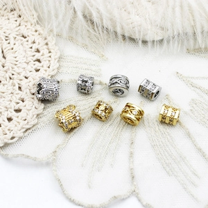 Detalle de dijes en oro de 18K y plata con circonitas para la creación de joyas DIY