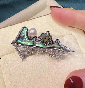 Macro detail of 18K gold-plated landscape brooch with abalone shell and pearl accent
