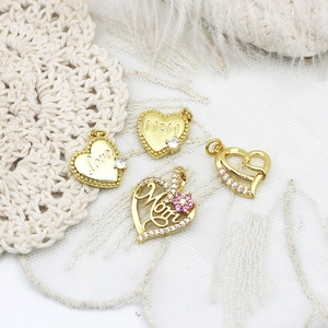 Macro shot of 18K gold plated heart pendants with zircon inlay and MOM engraving