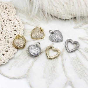 Detailed view of 18K gold and silver heart charms with zircons for jewelry making