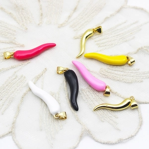 Détail de sept pendentifs piment colorés avec placage en or 18 carats sur dentelle