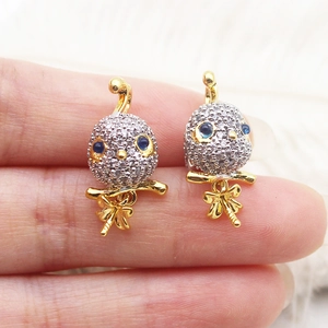 Two-tone micro-pave bird pendant with blue eyes and gold bow for jewelry making
