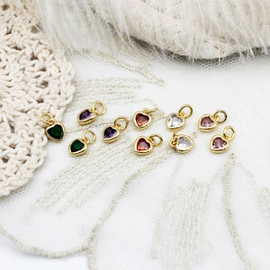 Detailed close-up of colorful heart charms with 18k gold plating for DIY jewelry crafting