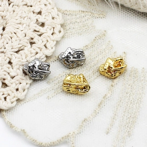 Makroaufnahme von gold- und silbernen Lavaperlen für DIY-Schmuckdesign mit Textur