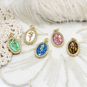 Detail view of oval flower pendants with 18K gold plated frames and zircon stones