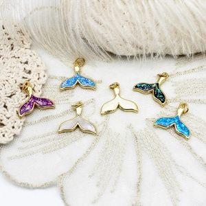 Detailed view of 18K gold plated whale tail pendants with colorful shimmering inlay