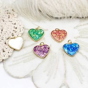 Detail of five 18K gold plated heart pendants with opal texture for DIY jewelry making