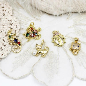 Macro view of gold-plated sea animal charms with colorful cubic zirconia for DIY jewelry