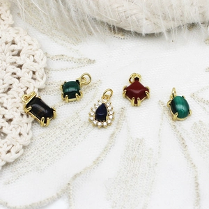 Detailed view of various gemstone pendants including tiger eye and malachite in gold settings