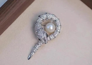 Détail de la broche serpent en argent avec zircons sertis et une grande perle blanche