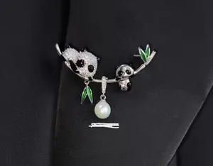 Détail macro d'une broche panda avec feuilles de bambou et perle sur un costume sombre