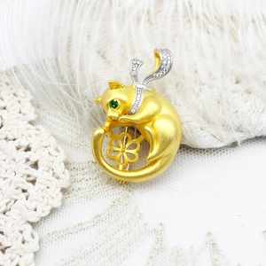 Broche chat élégante en or mat avec yeux en gemme verte et écharpe en diamants