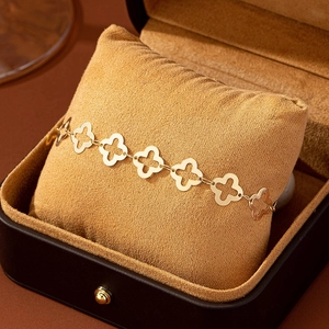 Elegantes goldenes Fußkettchen mit vierblättrigem Kleeblatt auf einer Schmuckschatulle