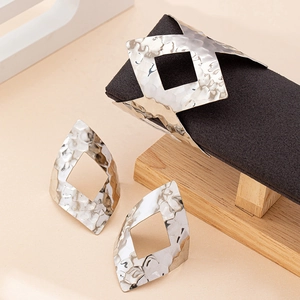 Set gioielli con bracciale geometrico traforato argento e orecchini a rombo effetto martellato