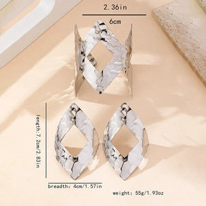 Dettaglio macro di set di gioielli geometrici in argento martellato con dimensioni