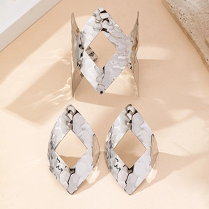 Dettaglio del set di gioielli martellati in argento con bracciale e orecchini geometrici