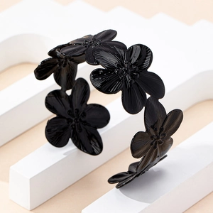 Detailed macro view of black floral open cuff bracelet with textured petals