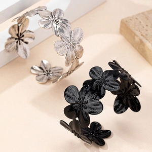 Detailed view of elegant flower open cuff bracelets in brushed silver and black finish