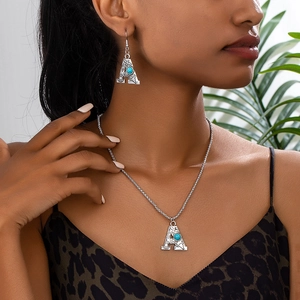 Vintage silver letter A necklace and earring set with turquoise stone on female model