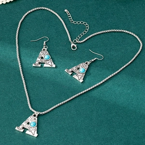 Detail of bohemian silver alloy letter A jewelry set with blue turquoise and carvings