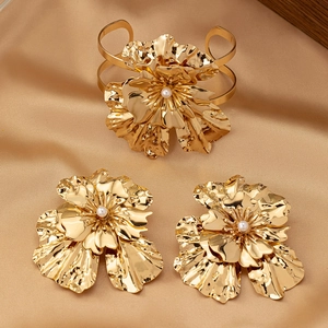 Golden flower jewelry set with pearls on satin including open bangle and earrings