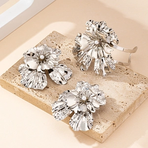 Detailed macro view of silver flower bracelet and earrings with elegant pearl center